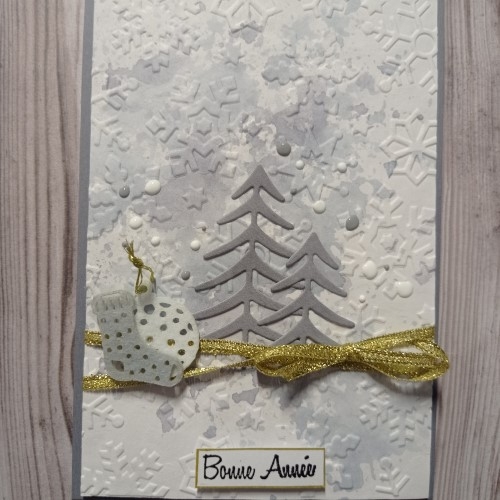 Une carte Bonne année sur fond de flocons embossés.
