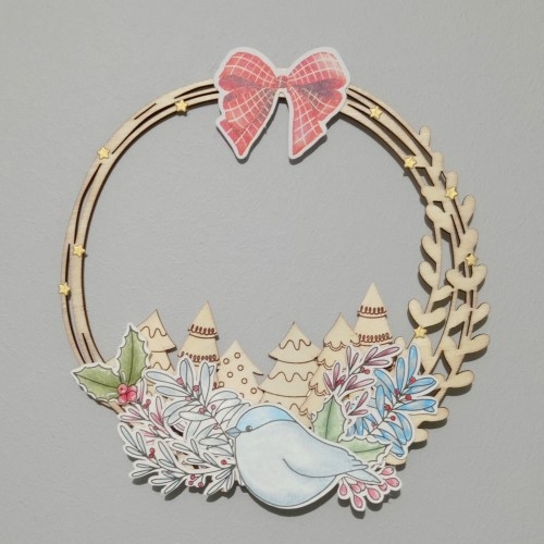 Une couronne en bois décorée de tamponnages, de die-cuts et de mini sapins en bois
