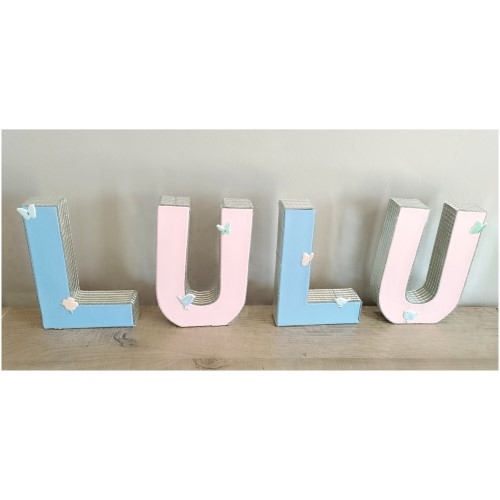 Décorer des lettres en papier-mâché de miroirs autocollants.